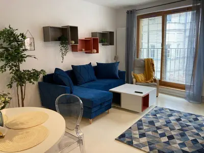 a living room with a blue couch and a table at Browar Lubicz 17b apartament 11 by Atrium Apartments in Kraków