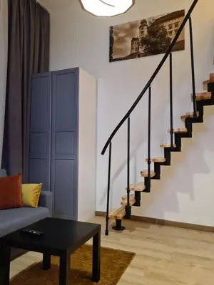a living room with a couch and stairs at AMBER APARTAMENT 1112 in Kraków