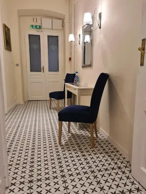 a hallway with a table and chairs on a tiled floor at AMBER APARTAMENT 1112 in Kraków