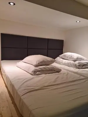 a large bed with white sheets and pillows at AMBER APARTAMENT 1112 in Kraków