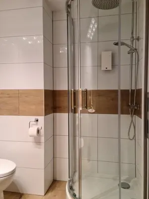 a shower with a glass door in a bathroom at AMBER APARTAMENT 1112 in Kraków