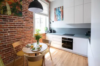 a kitchen with a table and chairs and a brick wall at Elegant Apartment Luminis in Krakow's Old City in Kraków