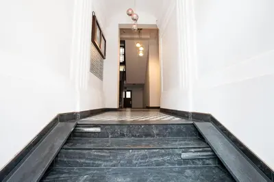 a hallway with a staircase in a building at Elegant Apartment Luminis in Krakow's Old City in Kraków