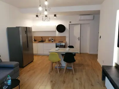 a kitchen and living room with a table and chairs at Kazimierz Old Town Apartments in Kraków