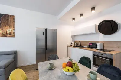 a kitchen with a table with a bowl of fruit on it at Kazimierz Old Town Apartments in Kraków