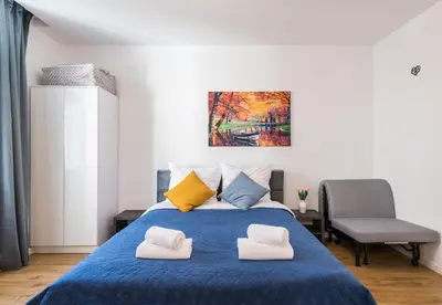a bedroom with a blue bed with two pillows at Kazimierz Old Town Apartments in Kraków