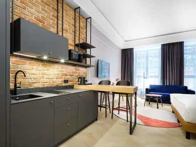 a bedroom with a bed and a living room at Mercure Krakow Fabryczna City in Kraków