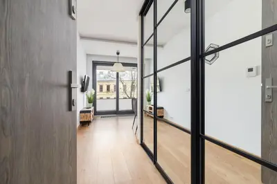 an open hallway with glass doors and a living room at Nadwiślańska 5 Apartments Kraków by Noclegi Renters in Kraków