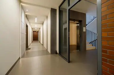 a corridor of a building with a glass door at Nadwiślańska 5 Apartments Kraków by Noclegi Renters in Kraków