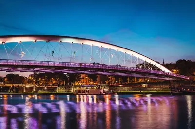 a bridge over the water at night with purple lights at Nadwiślańska 5 Apartments Kraków by Noclegi Renters in Kraków