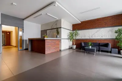 a lobby with chairs and a counter in a building at Nadwiślańska 5 Apartments Kraków by Noclegi Renters in Kraków