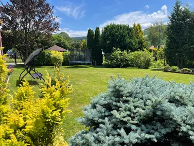 a garden with a statue in the grass at Dolce Vita in Mszana Dolna