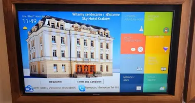 a television screen with a building on it at Sky Hotel Kraków in Kraków