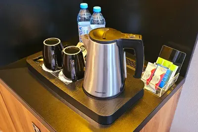 a tea kettle on a counter with bottles of water at Sky Hotel Kraków in Kraków