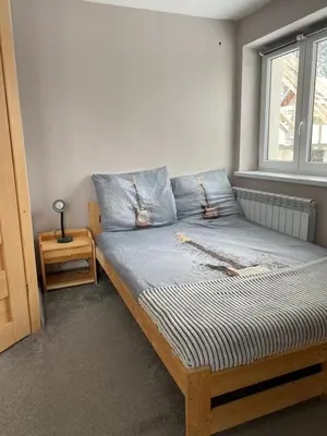 a bed in a room with a window at Nocleg pod Turbaczem in Nowy Targ