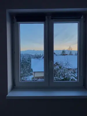 a window with two views of a snow covered field at Nocleg pod Turbaczem in Nowy Targ