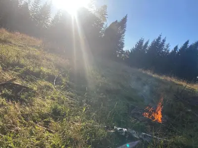 a fire in a field with the sun shining at Nocleg pod Turbaczem in Nowy Targ