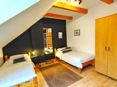 a bedroom with two beds and a black accent wall at Karczma Maciejówka in Czajowice
