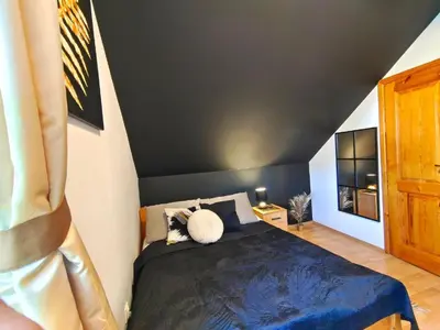 a bedroom with a bed with a black headboard at Karczma Maciejówka in Czajowice