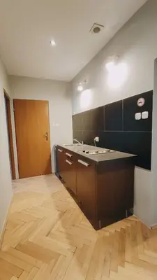a room with a kitchen with a wooden floor at Floriańska 10 by Homeprime in Kraków