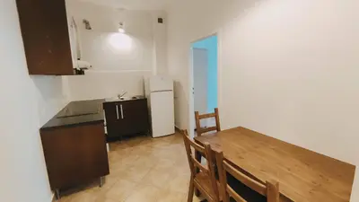 a kitchen with a wooden table and a refrigerator at Floriańska 10 by Homeprime in Kraków