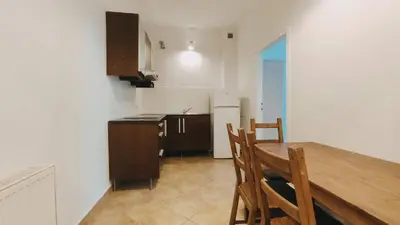 a kitchen with a wooden table and chairs in a room at Floriańska 10 by Homeprime in Kraków