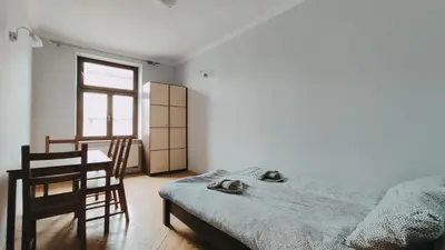 a bedroom with a bed and a chair and a window at Floriańska 10 by Homeprime in Kraków