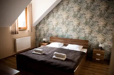 a bedroom with a bed with two towels on it at Pensjonat Zdrojowy in Rabka