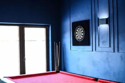 a room with a blue wall with a clock on the wall at Pensjonat Zdrojowy in Rabka