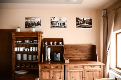 a kitchen with a wooden cabinet and a coffee maker at Pensjonat Zdrojowy in Rabka