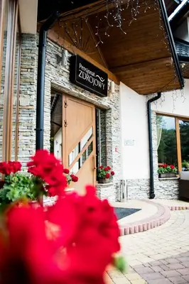 a store with red flowers in front of a building at Pensjonat Zdrojowy in Rabka