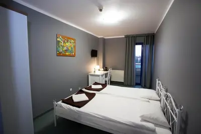 a bedroom with a white bed and a window at Hotel Kreator-Sport in Kraków