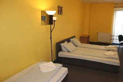 a living room with two beds and a lamp at Hotel Kreator-Sport in Kraków