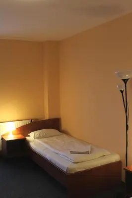 a bedroom with a bed and a lamp in it at Hotel Kreator-Sport in Kraków