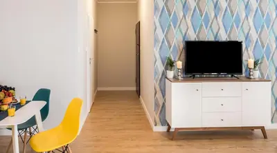 a living room with a tv on a white cabinet at Finale Apartments in Kraków