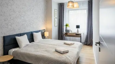 a bedroom with a bed with two pillows on it at Finale Apartments in Kraków
