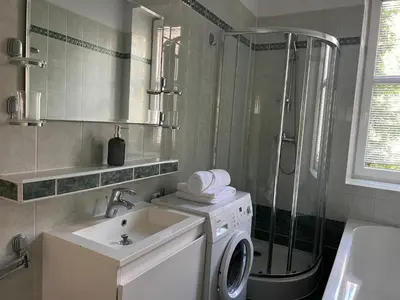 a bathroom with a washing machine and a shower at Finale Apartments in Kraków