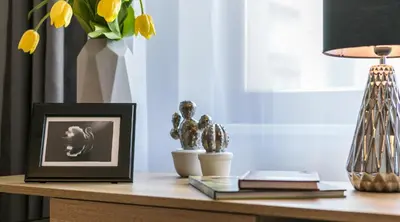 a desk with a picture and a lamp on a table at Finale Apartments in Kraków