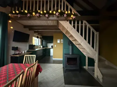 a living room with a staircase with a stove at Siedlisko Święty Spokój in Krzeszowice