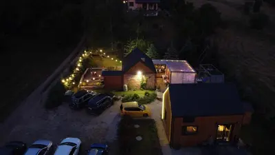 a house with cars parked in front of it at night at Siedlisko Święty Spokój in Krzeszowice