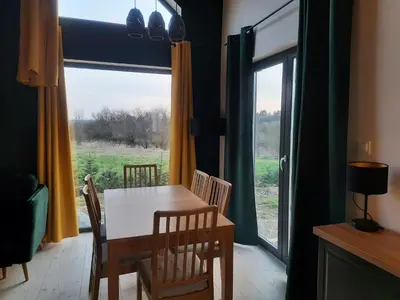 a dining room with a table and chairs and a window at Siedlisko Święty Spokój in Krzeszowice