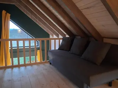 a couch in a room with a large window at Siedlisko Święty Spokój in Krzeszowice