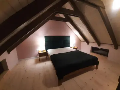 an attic bedroom with a bed and two night stands at Siedlisko Święty Spokój in Krzeszowice