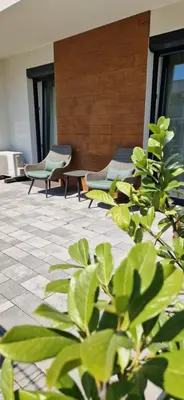 two chairs and a table in a building with plants at Apartamenty Parkowe B5 in Oświęcim