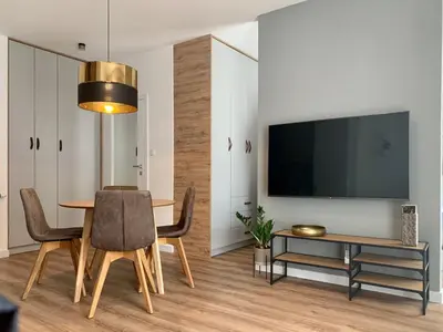 a dining room with a table and a tv at Apartamenty Parkowe B5 in Oświęcim