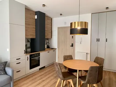 a kitchen and dining room with a table and chairs at Apartamenty Parkowe B5 in Oświęcim