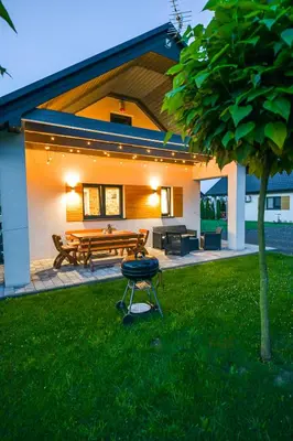 a grill in the grass in front of a house at Domki Pod Skarpą Zator in Zator