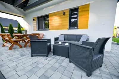 a patio with furniture and a table and chairs at Domki Pod Skarpą Zator in Zator