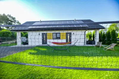 a house with a fence in front of it at Domki Pod Skarpą Zator in Zator