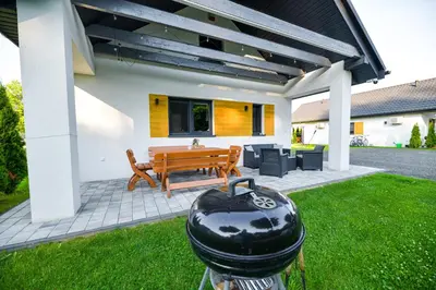 a barbecue grill in the yard of a house at Domki Pod Skarpą Zator in Zator